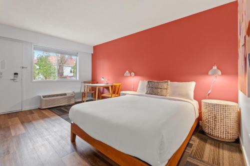 彭蒂克顿Okanagan Lakefront Resort的一间卧室设有一张大床和红色的墙壁