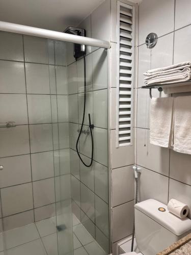 巴雷里尼亚斯Gran Lençóis Flat Residence的浴室设有玻璃淋浴间和卫生间