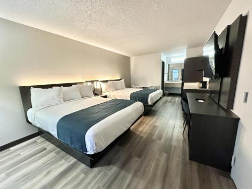 路易斯威尔Studio 6 Suites Louisville KY Airport/Expo Center的酒店客房配有两张床和一张书桌