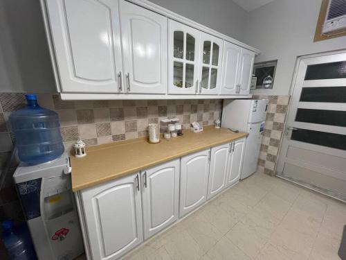 麦地那Fully furnished family house的厨房配有白色橱柜和冰箱。