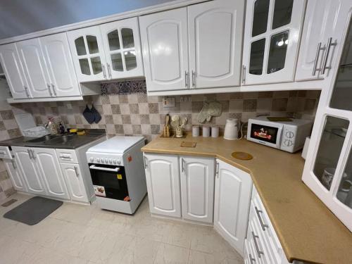 麦地那Fully furnished family house的厨房配有白色橱柜和白色家电