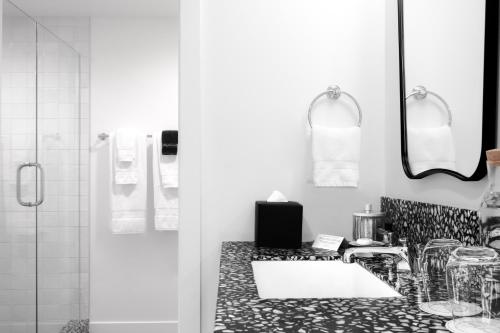 洛杉矶Short Stories Hotel的黑白浴室设有水槽和镜子