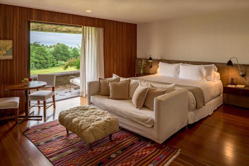 埃斯特角城Hotel Fasano Punta del Este的一间卧室配有一张大床和一张沙发