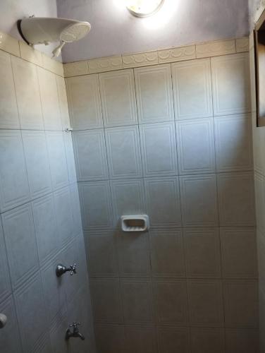 LuqueMangoty Apartamento的瓷砖浴室设有2个水龙头的淋浴