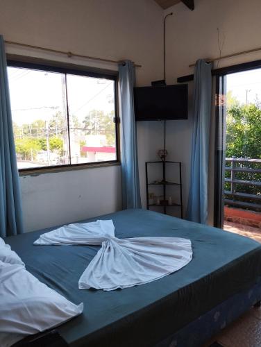 LuqueMangoty Apartamento的一张位于带两个大窗户的房间的床铺