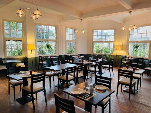 迪纳尔Hotel du Parc的餐厅设有桌椅和窗户。