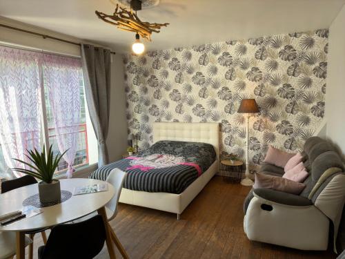 滨海布洛涅appartement vivier 4 personnes tout confort的一间卧室配有一张床、一张沙发和一张桌子