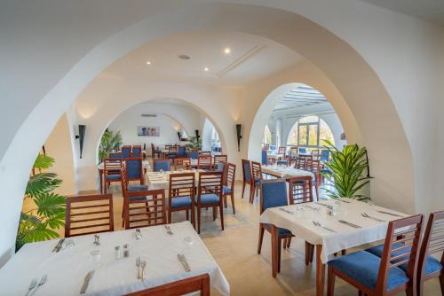 哈马马特Mediterranee Hammamet- Families and Couples Only的餐厅设有白色的桌子和蓝色的椅子