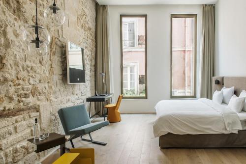 圣雷米普罗旺斯Hôtel de Tourrel, Saint Rémy de Provence, a Member of Design Hotels的一间卧室设有一张床和砖墙
