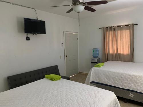 拉塞瓦Complejo Deportivo Wilson Palacios的一间卧室配有两张床和一台平面电视