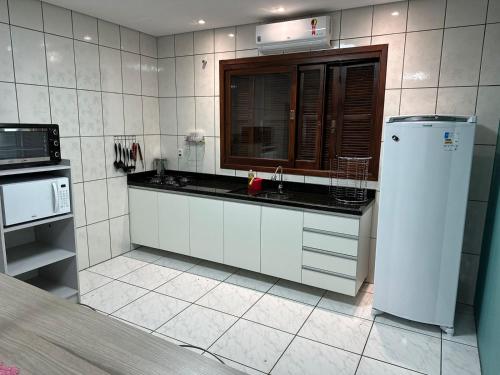新汉堡市Casa Liberdade的白色的厨房配有水槽和微波炉