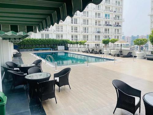 勒克瑙Grand DLF Stays的酒店庭院设有桌椅和游泳池