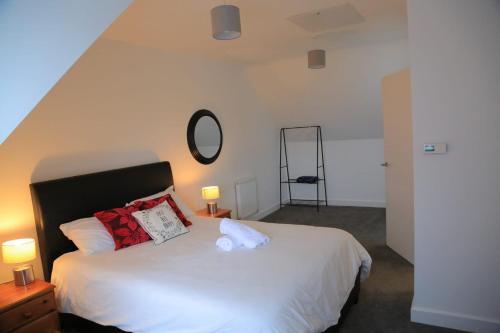 Cross GatesBeautiful New family home的卧室配有带红色枕头的大型白色床