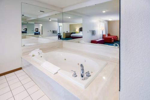 莱恩斯Alliance Hotel and Suites的客房内的白色大浴缸