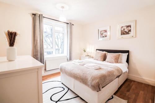 伦敦Fantastic 2 Bed London Apartment的白色的卧室设有床和窗户