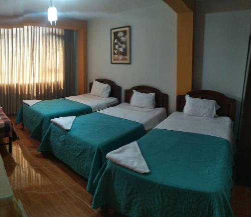 齐克拉约Hospedaje Concordia的酒店客房,配有两张带绿床单的床