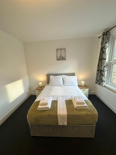 剑桥Cambridge Central Rooms - Tas Accommodations的一间卧室配有一张大床和两条毛巾