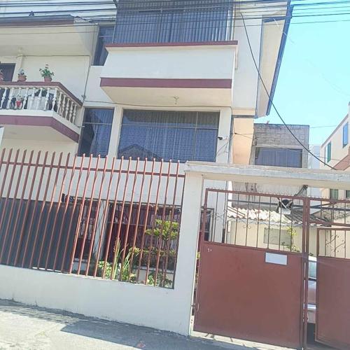 安巴托Agradable minidepartamento central en Ambato, para una a seis personas的白色的房子,设有大门和阳台