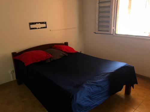 Le Morne RougeKAN'DLO的卧室内的一张床铺,配有蓝色毯子和窗户