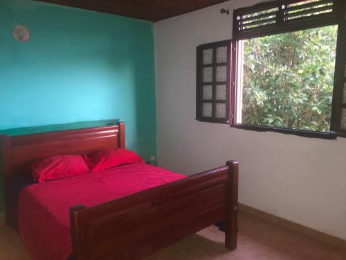 Le Morne RougeKAN'DLO的一间卧室配有一张带红色床单的床和一扇窗户。