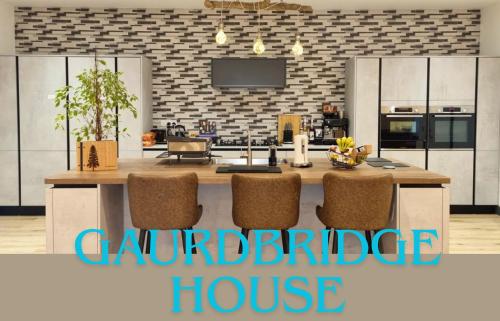 BalmulloGuardbridge House, Spacious Inside and Out, Golfer and Groups Favourite, 5 Beds, 2 Superking en suites, 3 Kingsize rooms, Bathroom & WC, Fully Equipped Kitchen, FREE Parking for 4 Large Vehicles, 10 mins to St Andrews, 15 mins to Dundee, BBQ的厨房配有带椅子的大厨房岛