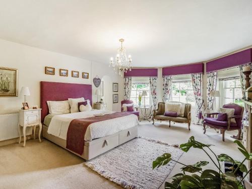 考布里奇Llwynhelig House - Uk46395的一间卧室配有一张特大号床,拥有紫色色调