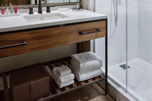 兀兰Houston CityPlace Marriott at Springwoods Village的浴室设有水槽和一堆毛巾