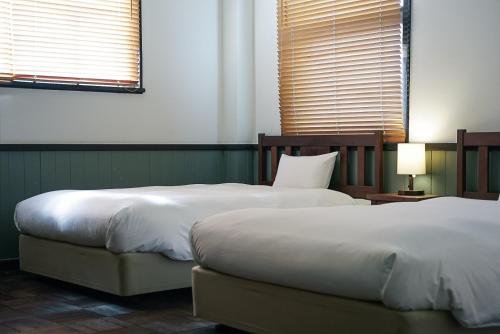 丰冈市Toyooka1925的卧室内两张并排的床