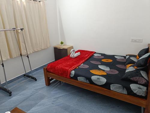 玛莱尤尔Bliss Villa 2 bedroom Apartment Marayoor的一间卧室配有一张带五颜六色棉被的床