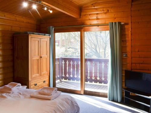 LegbourneRed Kite Lodge的一间卧室设有一张床和一个滑动玻璃门