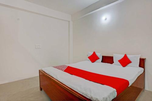 坎普尔OYO Flagship City Light Hotel的一间卧室配有红色和白色枕头的床