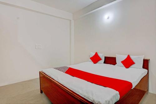 坎普尔OYO Flagship City Light Hotel的一间卧室配有一张带红色枕头的床