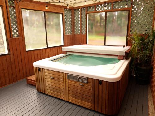 安吉利斯港Adventure's Home Base - Hot Tub & King Sized Bed的按摩浴缸位于客房中间