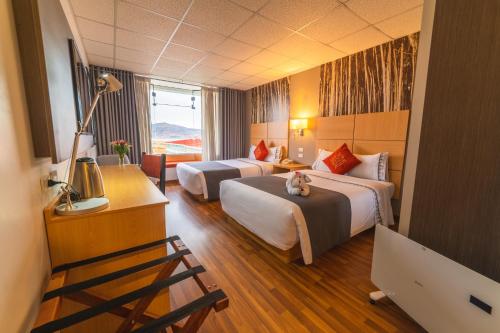 普诺Lake Titicaca Hotel的酒店客房设有两张床,床上还有一只猫