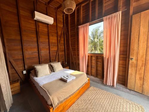奥尔沃克斯岛Mapache Hostel & Camping的一间带床的卧室,位于带窗户的房间内