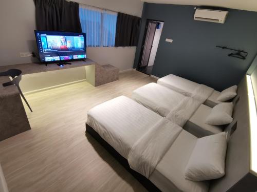 哥打巴鲁HOTEL SENTOSA KOTA BHARU Kelantan的一间卧室配有一张床和一台平面电视