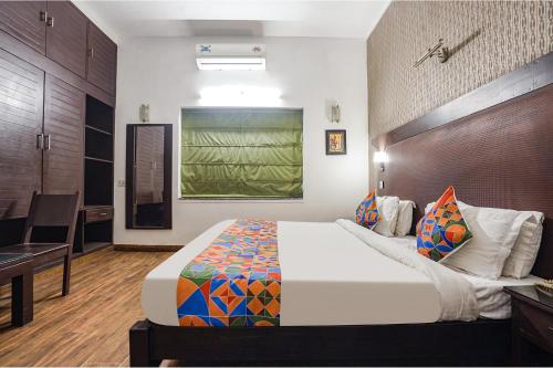 新德里FabHotel City Chalet Saket的一间卧室配有一张大床和一张书桌
