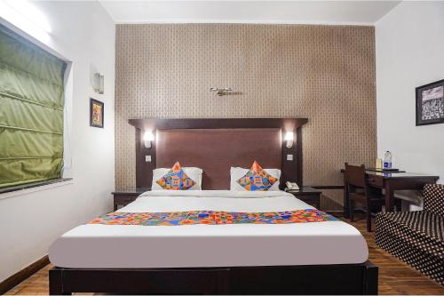 新德里FabHotel City Chalet Saket的一间卧室配有一张床和一张书桌