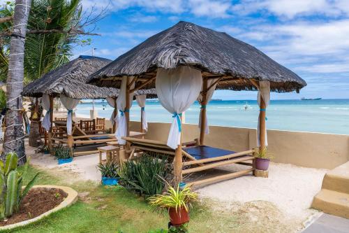 班塔延岛Sunrise Beach Club Resort Amanecer的海滩上设有椅子和遮阳伞,还有大海