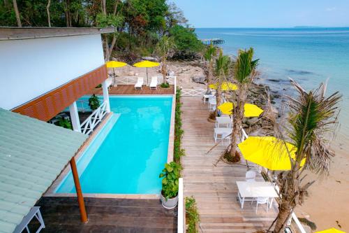 Phumĭ Kaôh Rŭng Sâmlœ̆m KhnŏngOne Beach Private Villa的一座带游泳池、椅子和遮阳伞的房子
