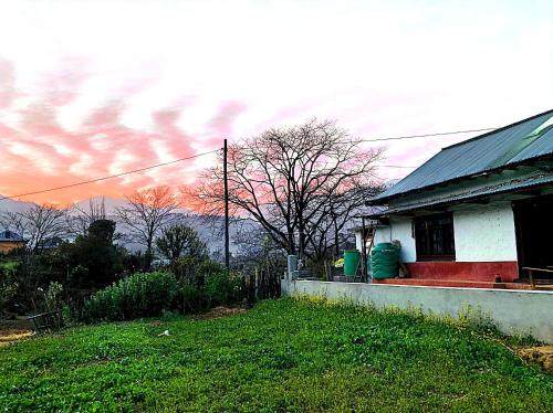 PanaotiSabitri Homestay的一座房子,有红色的门廊和云天