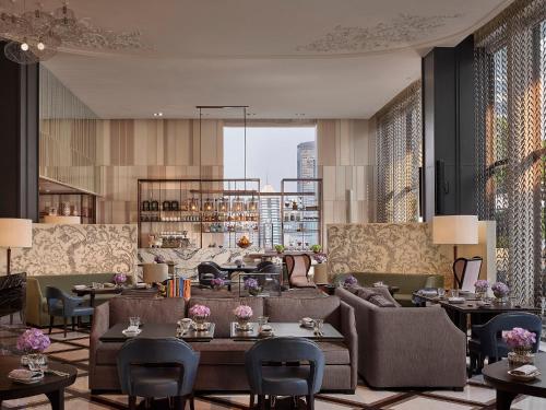 曼谷曼谷瑰丽酒店的酒店大堂设有沙发、桌子和窗户。