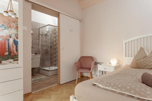 克韦什卡尔Köveskál Panzió的一间卧室配有一张床,浴室设有淋浴。