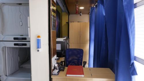 孟买Astropods的配有书桌和蓝色窗帘的房间