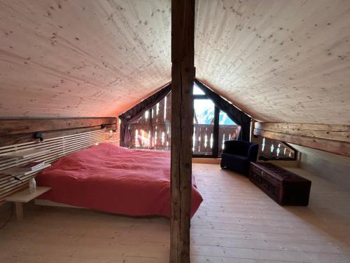 VnaBijoux in the Swiss mountains的阁楼卧室配有红色床