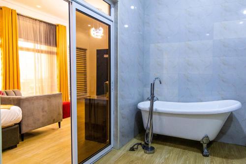OkpanamNelson Mandela Gardens的设有带浴缸和淋浴的浴室。