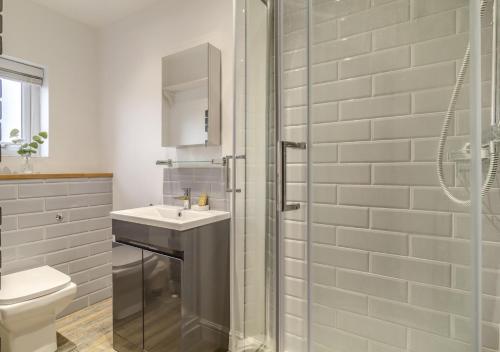 ReydonSeascape Cottage的带淋浴、盥洗盆和卫生间的浴室