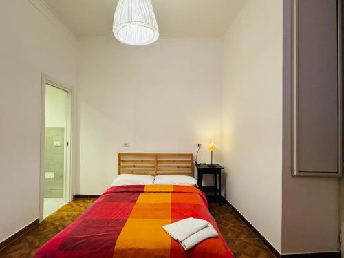 那不勒斯曼奇尼那不勒斯旅馆的一张床上,床上有五颜六色的毯子