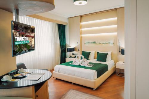 特拉布宗KONAK PARK HOTEL的酒店客房配有一张床铺和一张桌子。