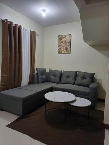 利帕Affordable 2 BR Transient House in Lipa City Batangas的客厅配有沙发和2张桌子